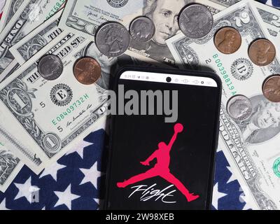 Deutschland. Dezember 2023. In dieser Fotoabbildung ist ein Air Jordan Logo auf einem Smartphone mit US-Dollar-Banknoten und -Münzen im Hintergrund zu sehen. (Foto von Igor Golovniov/SOPA Images/SIPA USA) *** ausschließlich für redaktionelle Nachrichten *** Credit: SIPA USA/Alamy Live News Stockfoto