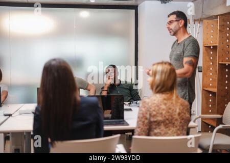 Der leitende Teamleiter bespricht das neue Projekt mit seinen Teamkollegen während des Meetings am Arbeitsplatz Stockfoto