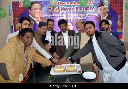 Präsident der Muslimischen Liga (PML-N), Kaleem Shaikh, schneidet einen Kuchen während einer Zeremonie anlässlich des Geburtstages von Quaid-e-Azam Muhammad Ali Jinnah und Nawaz Sharif am Montag, den 25. Dezember 2023 in Hyderabad. Stockfoto