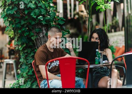 Schüler studieren und recherchieren nach dem Unterricht in einem Café, diskutieren Themen, helfen einander und bereiten sich auf Prüfungen vor. Stockfoto