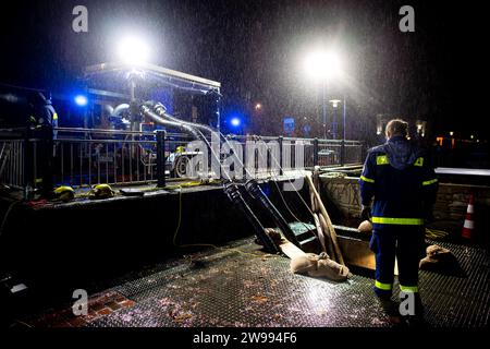 Oldenburg, Deutschland. Dezember 2023. Rettungsdienste des Bundesamtes für Technische Hilfe (THW) betreiben am Stadthafen eine Pumpe, um Wasser aus einem Rückhaltebecken in der Innenstadt in die Hunte zu pumpen. Aufgrund der Hochwassersituation hat die Stadt Oldenburg ein Einreiseverbot für die Deichgebiete und Wegewege erlassen. Die Hochwassersituation ist in vielen Regionen Niedersachsens über die Weihnachtsferien weiterhin angespannt. Quelle: Hauke-Christian Dittrich/dpa/Alamy Live News Stockfoto