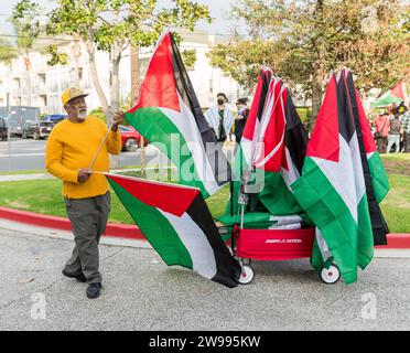 Mann, der palästinensische Flaggen bei der Demonstration "Black and Palestinian Solidarity for a Ceasefire this Christmas" in Beverly Hills, Kalifornien am 23. Dezember 2023 verkauft. Stockfoto