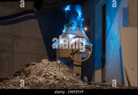 Alternativer Weihnachtsbaum, der mit einem elektrischen Betonmischer in einem Haus im Bau gebaut wurde. Weihnachtslichter im Kreis angeordnet. Stockfoto