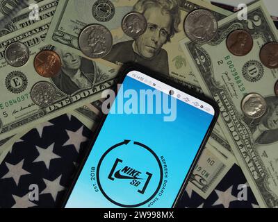 Bayern, Deutschland - 25. Dezember. 2023: In dieser Fotoabbildung wird ein Nike Skateboarding Logo auf einem Smartphone mit US-Dollar angezeigt Stockfoto