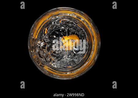 Ein Glas Wasser mit leuchtenden Orangenfrüchten Stockfoto