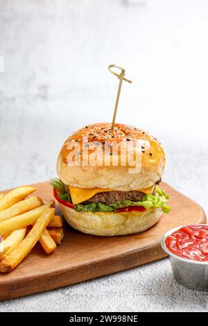Bild eines einlagigen Burger-Sandwiches mit einer Seite Pommes Frites auf weißem Hintergrund Stockfoto