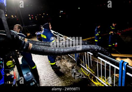 Oldenburg, Deutschland. Dezember 2023. Rettungsdienste des Bundesamtes für Technische Hilfe (THW) betreiben am Stadthafen eine Pumpe, um Wasser aus einem Rückhaltebecken in der Innenstadt in die Hunte zu pumpen. Aufgrund der Hochwassersituation hat die Stadt Oldenburg ein Einreiseverbot für die Deichgebiete und Wegewege erlassen. Die Hochwassersituation ist in vielen Regionen Niedersachsens über die Weihnachtsferien weiterhin angespannt. Quelle: Hauke-Christian Dittrich/dpa/Alamy Live News Stockfoto