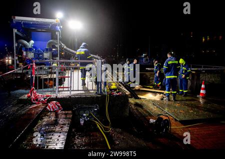 Oldenburg, Deutschland. Dezember 2023. Rettungsdienste des Bundesamtes für Technische Hilfe (THW) betreiben am Stadthafen eine Pumpe, um Wasser aus einem Rückhaltebecken in der Innenstadt in die Hunte zu pumpen. Aufgrund der Hochwassersituation hat die Stadt Oldenburg ein Einreiseverbot für die Deichgebiete und Wegewege erlassen. Die Hochwassersituation ist in vielen Regionen Niedersachsens über die Weihnachtsferien weiterhin angespannt. Quelle: Hauke-Christian Dittrich/dpa/Alamy Live News Stockfoto