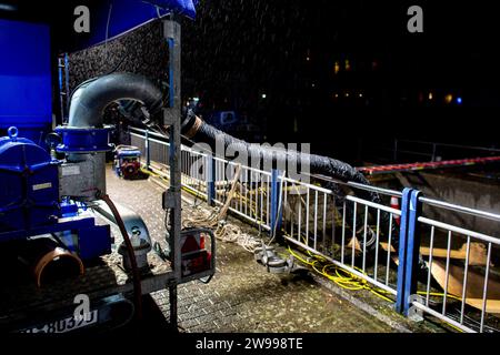 Oldenburg, Deutschland. Dezember 2023. Rettungsdienste des Bundesamtes für Technische Hilfe (THW) betreiben am Stadthafen eine Pumpe, um Wasser aus einem Rückhaltebecken in der Innenstadt in die Hunte zu pumpen. Aufgrund der Hochwassersituation hat die Stadt Oldenburg ein Einreiseverbot für die Deichgebiete und Wegewege erlassen. Die Hochwassersituation ist in vielen Regionen Niedersachsens über die Weihnachtsferien weiterhin angespannt. Quelle: Hauke-Christian Dittrich/dpa/Alamy Live News Stockfoto