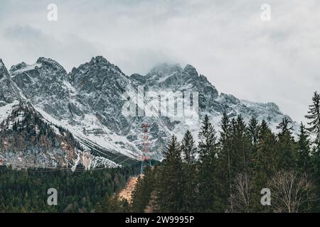 Ein malerischer Blick auf einen schneebedeckten Berggipfel, umgeben von einem üppigen Wald in den österreichischen alpen Stockfoto