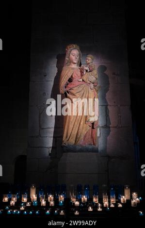 Detail der Statuette der Jungfrau mit dem Kind in der Kathedrale Saint-Malo, dunkler Hintergrund und unten sind Kerzen angezündet Stockfoto