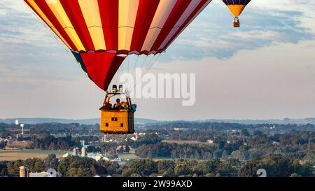 Aus nächster Nähe sehen Sie Heißluftballons, die im ländlichen Pennsylvania bei Sonnenaufgang an einem sonnigen Sommermorgen davonfliegen Stockfoto