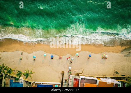 Von oben nach unten gesehen vom Strand und dem farbenfrohen Meer mit Sonnenschirmen Stockfoto