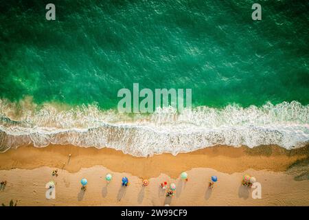 Drone oben unten Aufnahme des Strandes und des farbenfrohen Ozeans mit Sonnenschirmen Stockfoto