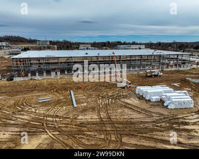 Ein Blick aus der Vogelperspektive auf das Grundgerüst einer riesigen Industrieanlage mit Materialien und Erdbewegern, die den frühen Bau prägten Stockfoto