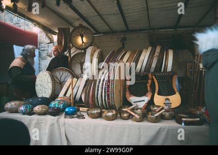 Auf einem Tisch im Schatten eines weißen Zeltes im Freien stehen verschiedene Musikinstrumente Stockfoto