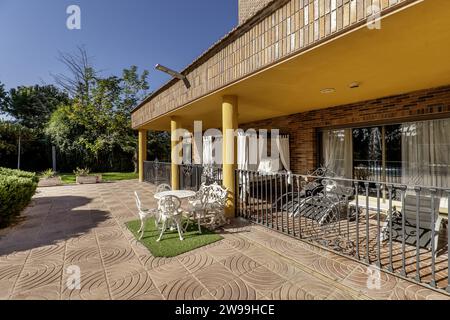 Ein luxuriöses Einfamilienhaus mit großen Gärten und einer Veranda mit balinesischem Bett, Hängematten und Metallgeländer Stockfoto