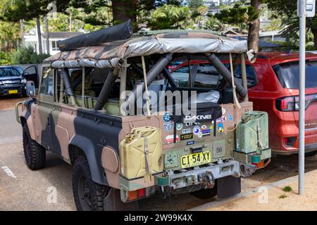 1989 Modell Land Rover Defender in Tarnfarben der Armee, parkt am Palm Beach in Sydney, NSW, Australien Stockfoto