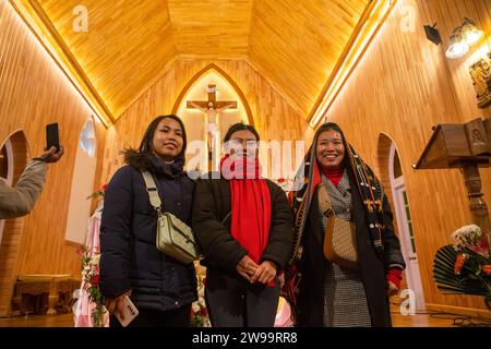 Srinagar, Indien. Dezember 2023. Christliche Gläubige posieren für ein Foto in der katholischen Kirche der Heiligen Familie an einem Weihnachtstag in Srinagar. Die umstrittene Himalaya-Region Kaschmirs hat eine winzige Bevölkerung von Christen, von denen Hunderte an Weihnachten an der Messe in der katholischen Kirche der Heiligen Familie teilnehmen und für Frieden in Kaschmir und Palästina beten. Viele kommen in Weihnachtskostümen, um Weihnachten zu feiern. Quelle: SOPA Images Limited/Alamy Live News Stockfoto