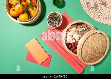 Mandarinen, Marmeladen, Jujubes und gesalzene getrocknete Früchte werden in Bambus-Dampfkörben gelagert. Teetisch mit Tet-Geschirr. Kopierraum für Werbung mit Flat Stockfoto