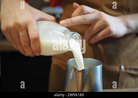 Milch aus einer Flasche gießen Stockfoto
