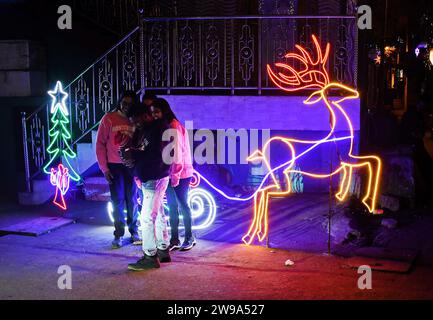 Mumbai, Indien. Dezember 2023. Man sieht Menschen, die neben einer Lichtinstallation eines Rentiers stehen, der einen Schlitten zieht, der auf der Straße gehalten wird, um das Weihnachtsfest in Mumbai zu feiern. Weihnachten wird in aller Welt gefeiert, um an die Geburt Jesu Christi zu erinnern. Menschen aus der christlichen Gemeinde schmücken ihr Haus mit Weihnachtsbaum und Lichtern, tauschen Geschenke aus und Familienmitglieder versammeln sich zu einem fest, um den Anlass zusammen mit ihren nahen und lieben Menschen zu feiern. Quelle: SOPA Images Limited/Alamy Live News Stockfoto