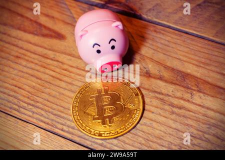 Bitcoin auf hölzernem Hintergrund mit einer Schweinebank an der Seite . Das Konzept der Bitcoin-Investitionen und -Einsparungen . Stockfoto