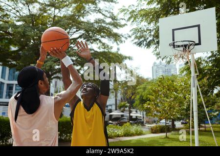 Junge Schwarze Männer spielen gerne im Freien Basketball Stockfoto