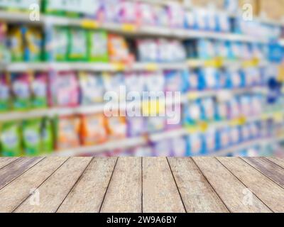 Holztischplatte mit Waschmittelregalen im Wäschereibereich im Supermarkt oder Lebensmittelgeschäft verschwommener Hintergrund Stockfoto