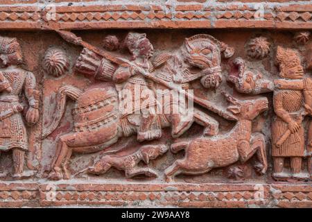 Nahaufnahme der geschnitzten Terrakotta-Jagdszene von Jägern auf Pferden, die Hirsche auf dem alten Govinda-Tempel in Puthia, Rajshahi, Bangladesch jagen Stockfoto