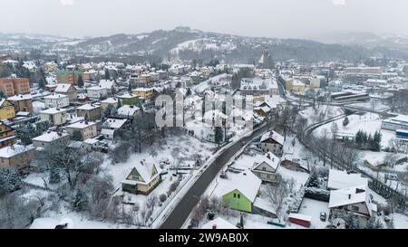 Drohnenaufnahme einer kleinen Stadt namens Limanowa in den Bergen in Polen, die von Nebel und Schnee bedeckt sind Stockfoto