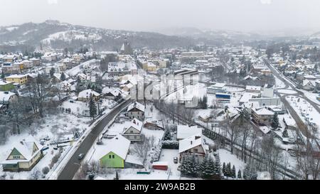 Drohnenaufnahme einer kleinen Stadt namens Limanowa in den Bergen in Polen, die von Nebel und Schnee bedeckt sind Stockfoto