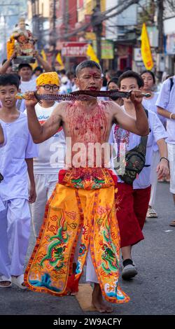 Ein Gläubiger läuft in einer Prozession, während er sich während des jährlichen Vegetarian Festival in Phuket Town, Thailand, schneidet. Thailands touristische Zahlen sind o Stockfoto