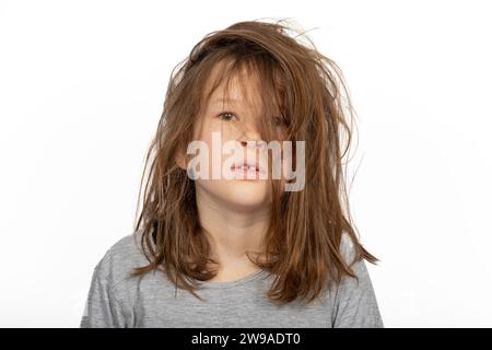 Grumpy Christmas Morning: Porträt eines jungen Mädchens mit einem Bad Hair Day auf weißem Hintergrund Stockfoto