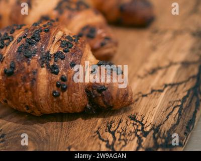 Vintage frisch gebackene leckere Schokoladen Croissants aus der Nähe auf einem hölzernen Schneidebrett Stockfoto