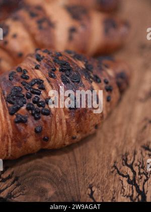 Vintage frisch gebackene leckere Schokoladen Croissants aus der Nähe auf einem hölzernen Schneidebrett Stockfoto