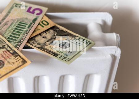 Ein Haufen US-Dollar auf einem Heizkörper. Ein Heizungs- und Energiekostenkonzept. Stockfoto