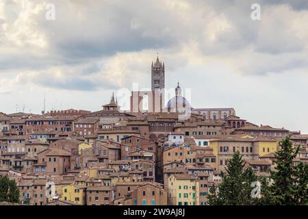 SIENA, ITALIEN - 14. SEPTEMBER 2018: Dies ist ein mittelalterliches Stadtgebäude mit einer Kathedrale auf einem bebauten Hügel. Stockfoto