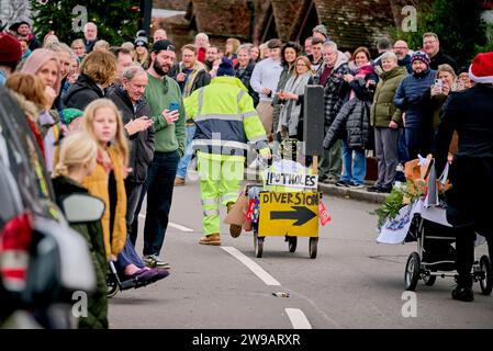 East Hoathly, Großbritannien. Dezember 2023. Kinderwagenrennen am Boxing Day: Teams in schicken Kleidern laufen durch das Dorf East Hoathly in East Sussex und sammeln Spenden für lokale Wohltätigkeitsorganisationen. Die jährliche Veranstaltung beginnt und endet im Kings Head Pub im Zentrum des Dorfes. Quelle: Jim Holden/Alamy Live News Stockfoto