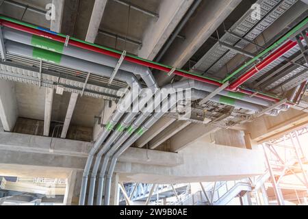 Rohre verschiedener Durchmesserdurchmesser unter der Decke eines öffentlichen Bahnhofsgebäudes Stockfoto