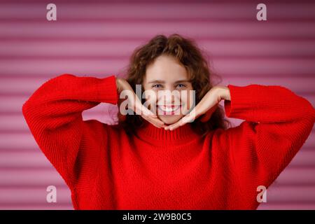 Junge rothaarige Frau, die Gesichtsyoga, Gesichtsgymnastik, Selbstmassage und Gesichtsaufbauübung macht Stockfoto