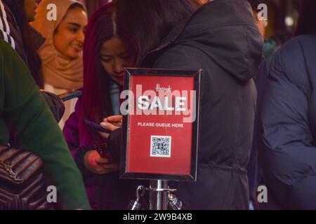 London, Großbritannien. Dezember 2023. Kunden stehen vor dem Kaufhaus Harrods in Knightsbridge für den Verkauf am zweiten Weihnachtsfeiertag an. Quelle: SOPA Images Limited/Alamy Live News Stockfoto