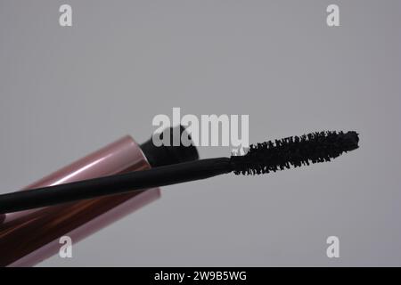 Damenkosmetik, schöne rosa Metall Augenbürste, schwarze stilvolle Mascara Set auf weißem Hintergrund. Stockfoto