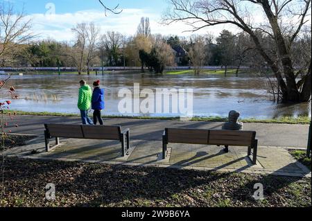 26. Dezember 2023, Sachsen-Anhalt, Halle (Saale): Wanderer entlang der Hochwassersaale. Der Wasserstand des Flusses ist stark gestiegen. Längere Regenfälle und Auftauen in den Bergen haben dazu geführt, dass das Wasser über seine Ufer fließt. Foto: Heiko Rebsch/dpa Stockfoto