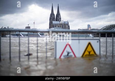 Hochwasser in Köln die Absperrung, auf der hängt ein Schild, auf dem steht Hochwasser Lebensgefahr , Gefahr, AUSSEND when fluded , auf dem Hintergrund sehen wir Kölner Dom Hochwasser in Köln, Symbolbild, 26.12.2023. Köln NRW Deutschland *** Hochwasser in Köln die Barriere, an der ein Schild mit der Aufschrift Hochwasser Lebensgefahr, Gefahr, bei Überflutung fernhalten, auf dem Hintergrund sehen wir Kölner Dom Hochwasser in Köln, symbolisches Bild, 26 12 2023 Köln NRW Deutschland Copyright: XBEAUTIFULxSPORTS/Buriakovx Stockfoto