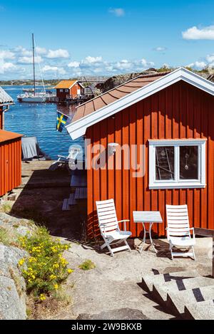 Traditionelle rote schwedische Holzhütten vor dem Badeplatz in Stocken im Archipel der Westküste Schwedens in der Sommersonne Stockfoto