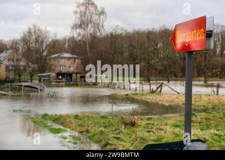 Olfen, NRW, Deutschland. Dezember 2023. Ein Zeichen für einen inzwischen überfluteten Biergarten. Der Fluss Stever und seine Seitenarme haben große Teile der umliegenden Landschaft stark überflutet. In der Nähe der Stever Bridge, einer historischen Dreibogenbrücke, die früher kleine Boote in einem Kanal über den Fluss Stever transportierte (heute eine Fußbrücke), sind die umliegenden Felder knietief überflutet. Weite Teile Nord- und Westdeutschlands haben nach wochenlangen Starkregen Überschwemmungen erlebt. Die Prognose ist für mehr Regen. Quelle: Imageplotter/Alamy Live News Stockfoto