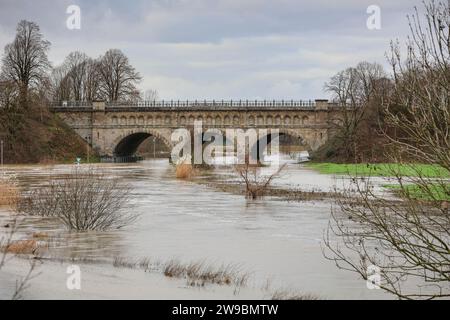 Olfen, NRW, Deutschland. Dezember 2023. Die historische Brücke. Der Fluss Stever und seine Seitenarme haben große Teile der umliegenden Landschaft stark überflutet. In der Nähe der Stever Bridge, einer historischen Dreibogenbrücke, die früher kleine Boote in einem Kanal über den Fluss Stever transportierte (heute eine Fußbrücke), sind die umliegenden Felder knietief überflutet. Weite Teile Nord- und Westdeutschlands haben nach wochenlangen Starkregen Überschwemmungen erlebt. Die Prognose ist für mehr Regen. Quelle: Imageplotter/Alamy Live News Stockfoto