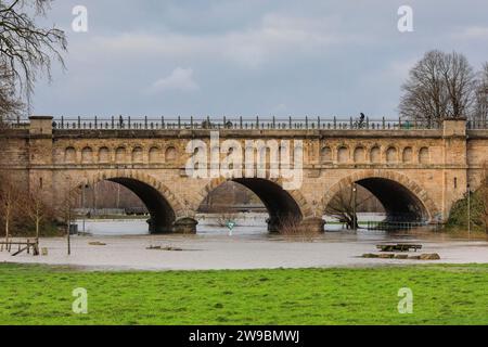 Olfen, NRW, Deutschland. Dezember 2023. Die historische Brücke. Der Fluss Stever und seine Seitenarme haben große Teile der umliegenden Landschaft stark überflutet. In der Nähe der Stever Bridge, einer historischen Dreibogenbrücke, die früher kleine Boote in einem Kanal über den Fluss Stever transportierte (heute eine Fußbrücke), sind die umliegenden Felder knietief überflutet. Weite Teile Nord- und Westdeutschlands haben nach wochenlangen Starkregen Überschwemmungen erlebt. Die Prognose ist für mehr Regen. Quelle: Imageplotter/Alamy Live News Stockfoto