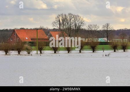 Olfen, NRW, Deutschland. Dezember 2023. Der Fluss nähert sich den umliegenden Farmen. Der Fluss Stever und seine Seitenarme haben große Teile der umliegenden Landschaft stark überflutet. In der Nähe der Stever Bridge, einer historischen Dreibogenbrücke, die früher kleine Boote in einem Kanal über den Fluss Stever transportierte (heute eine Fußbrücke), sind die umliegenden Felder knietief überflutet. Weite Teile Nord- und Westdeutschlands haben nach wochenlangen Starkregen Überschwemmungen erlebt. Die Prognose ist für mehr Regen. Quelle: Imageplotter/Alamy Live News Stockfoto